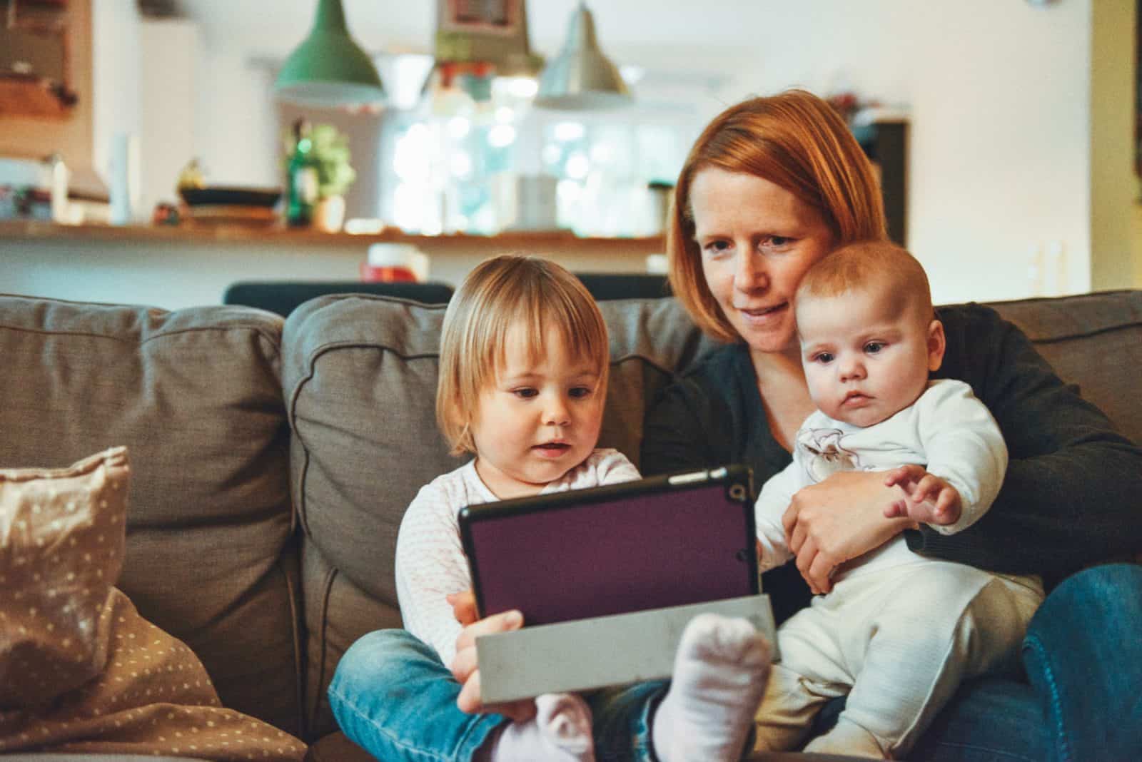 woman reading to children on the couch