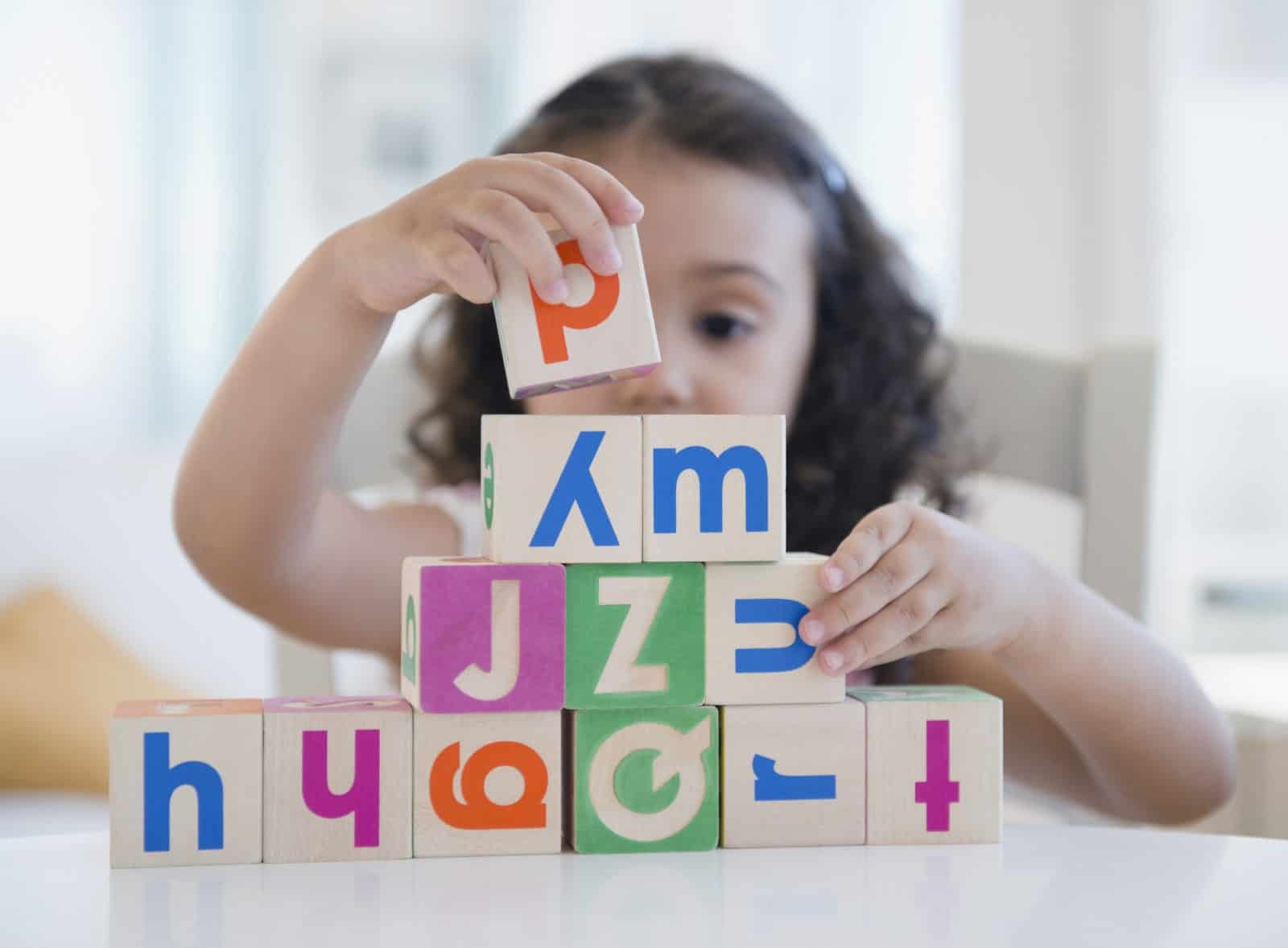 Mixed race girl stacking blocks