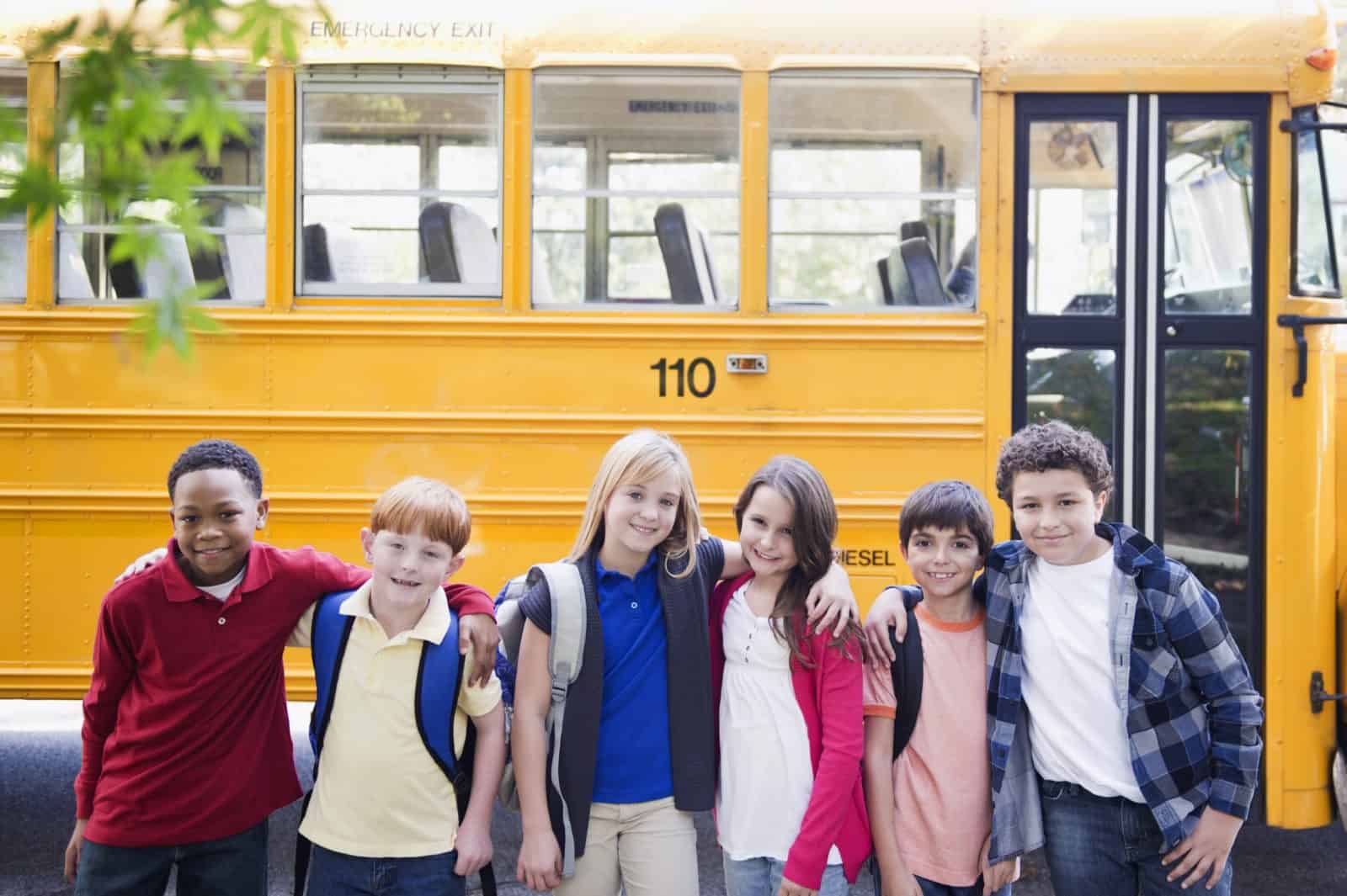 children in front of a bus