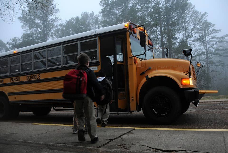 children getting on school bu