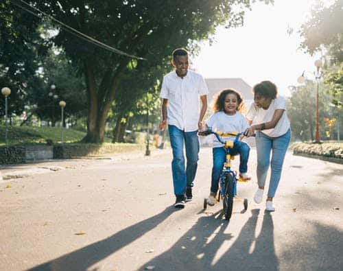 mom dad and child on bicycle