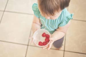 toddler holding berries