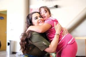 woman hugging child with downs syndrome