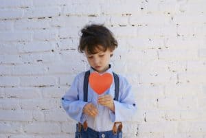 Young boy holding a paper heart