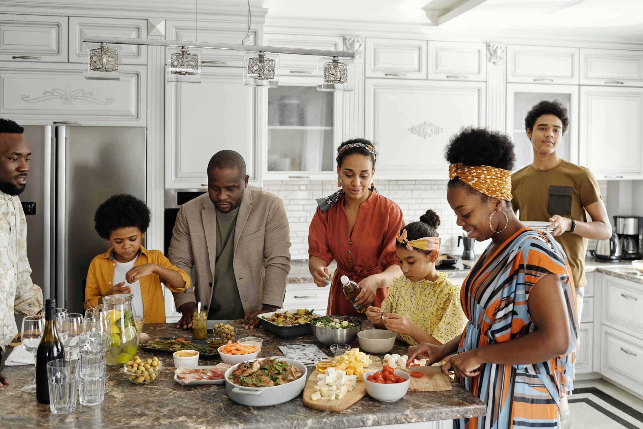 A family hanging out in the kitchen together and preparing a meal