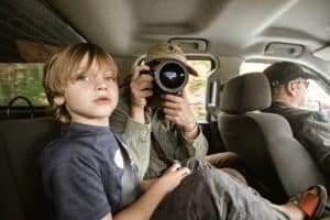 boy in car with mom taking photo